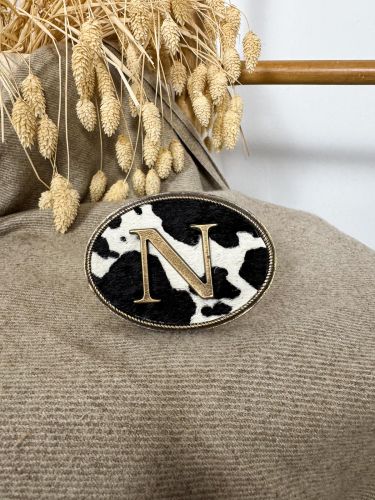 Hebilla ovalada pelo vaca inicial relieve N
