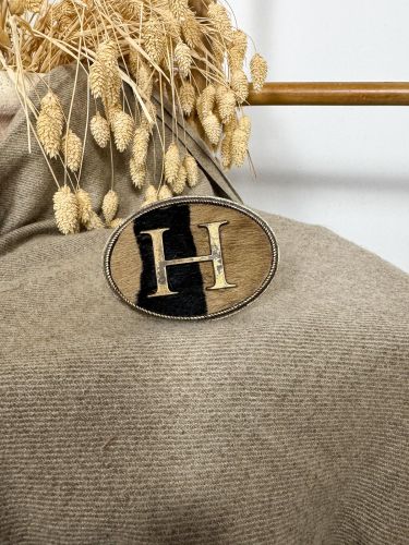 Hebilla ovalada pelo marrón y negro inicial relieve G