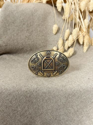 Hebilla ovalada pequeña labrada estribo y palos color oro...