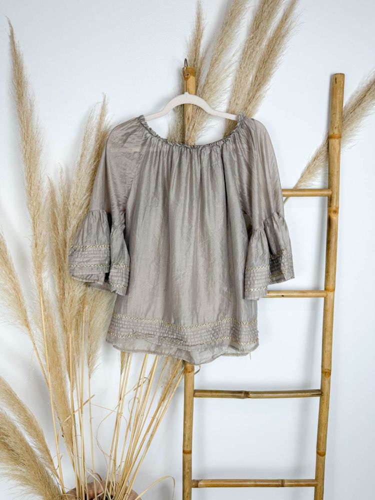 Blusa taupe  maxi volante en las mangas con mini colantitos y trenzado dorado