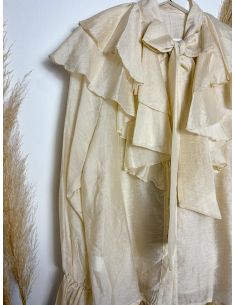 Blusa beige con volantes y lazada al cuello